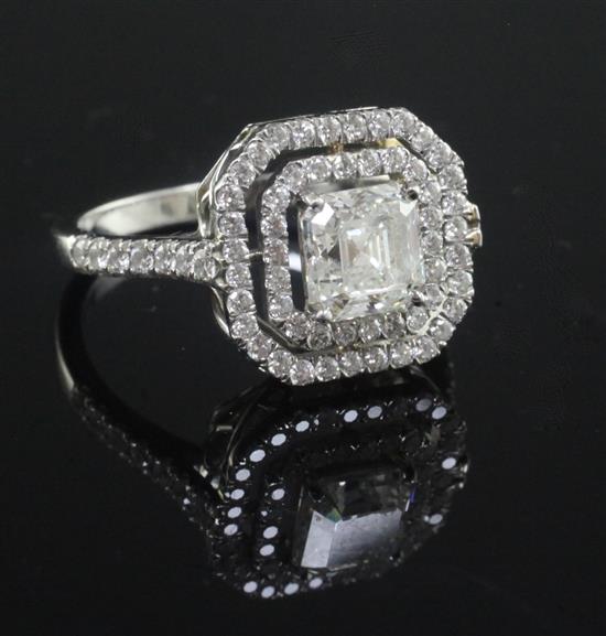 A white gold and single stone asscher cut diamond ring bordered with two concentric octagonal bands of brilliants, size O.